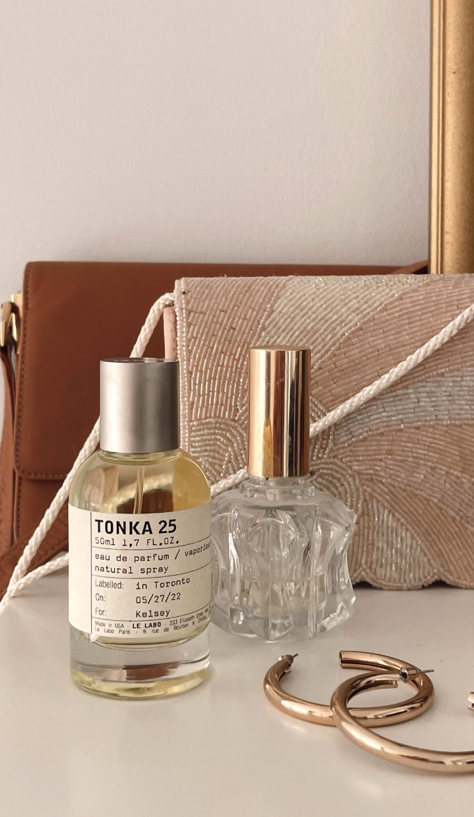 Le Labo Tonka 45 fragrance amid gold hoop earrings.