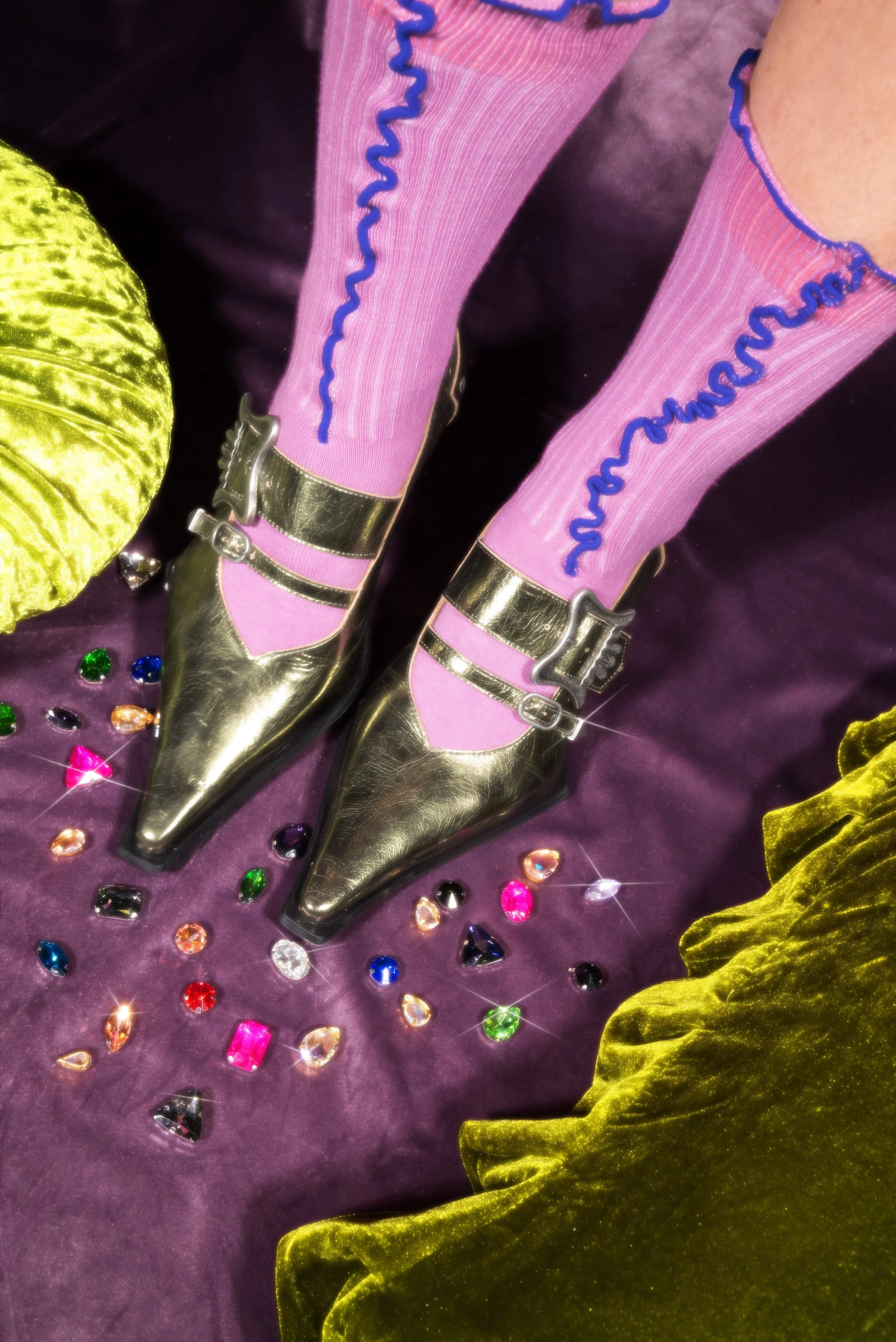 Birds eye view of a gold metallic pointed shoe being modeled on foot.