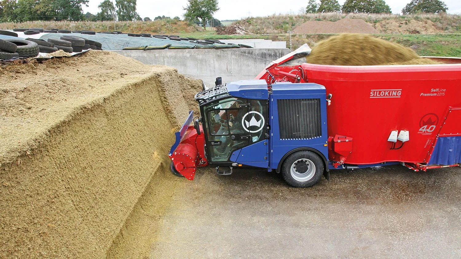 A Siloking SelfLine Premium 2215 self-propelled vertical mixer cleanly extracting silage from a tightly packed bunker face using its heavy-duty milling arm.