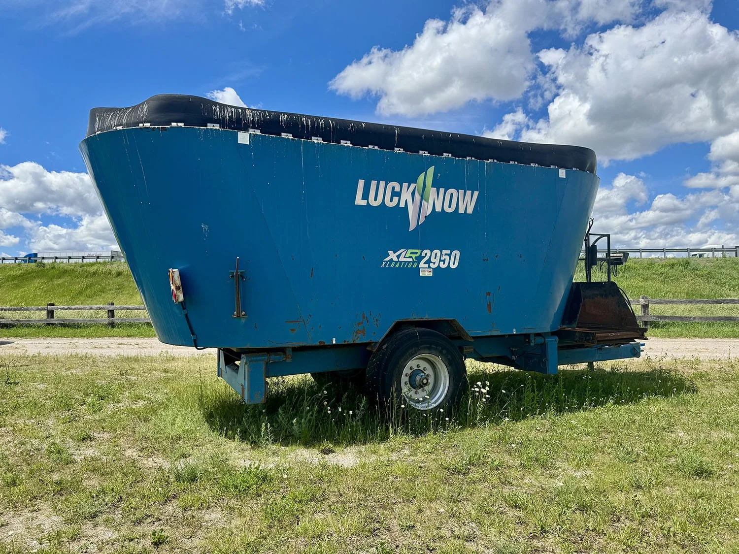 Full side profile view of a blue Lucknow XLRATION XLR2950 vertical mixer wagon on a single axle with a black tub extension.