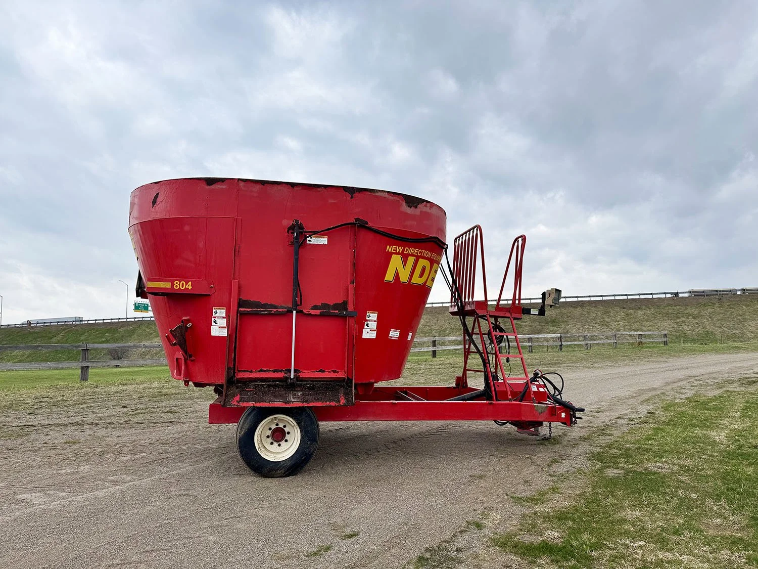 Right side profile view of a red used 2014 NDE 804 vertical mixer wagon on a single axle showing the front access platform and ladder.