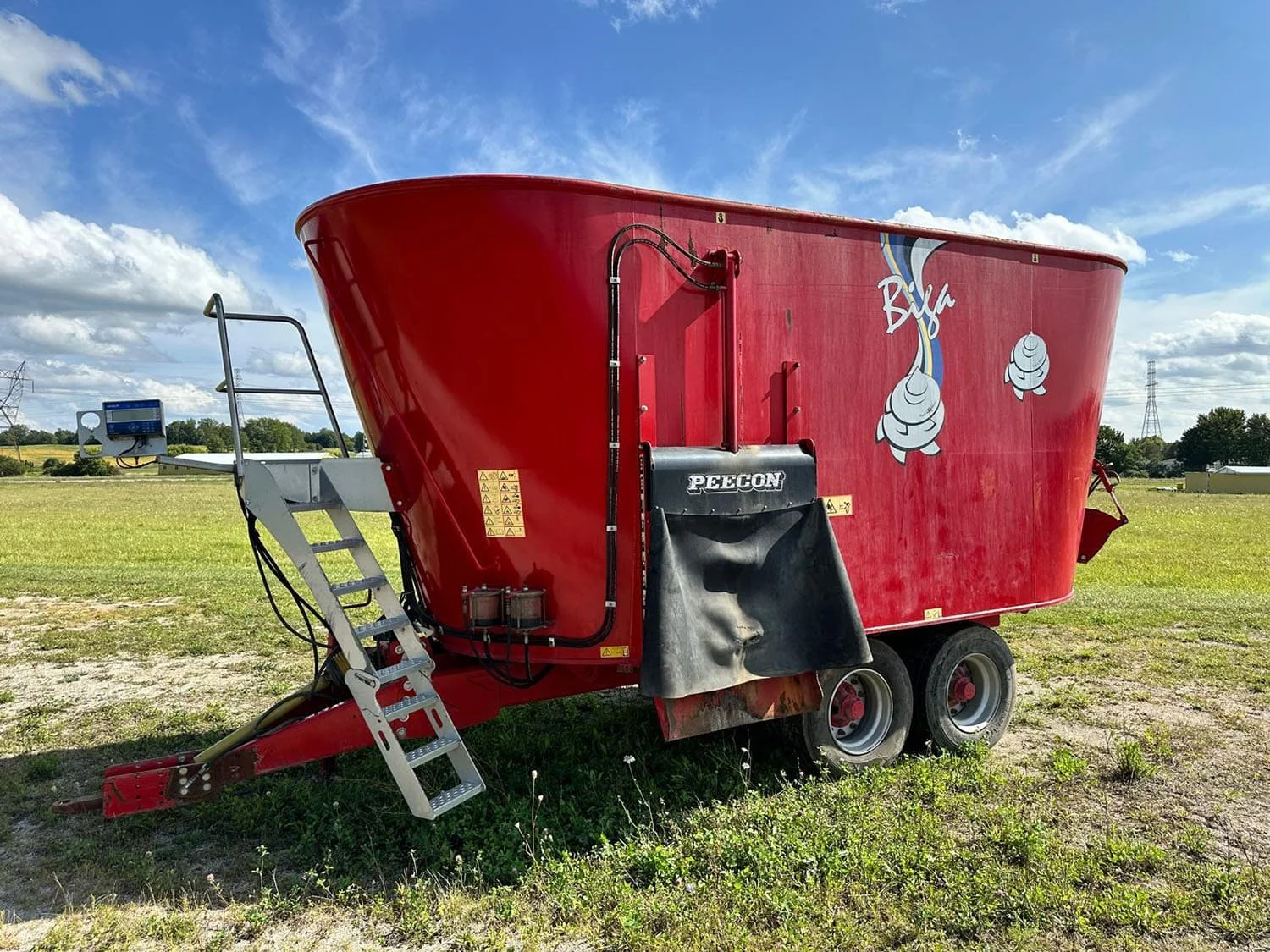Used red 2015 Peecon VME 300 Biga trailed vertical TMR feed mixer wagon side view showing left discharge door and front ladder for sale at Siloking Canada.