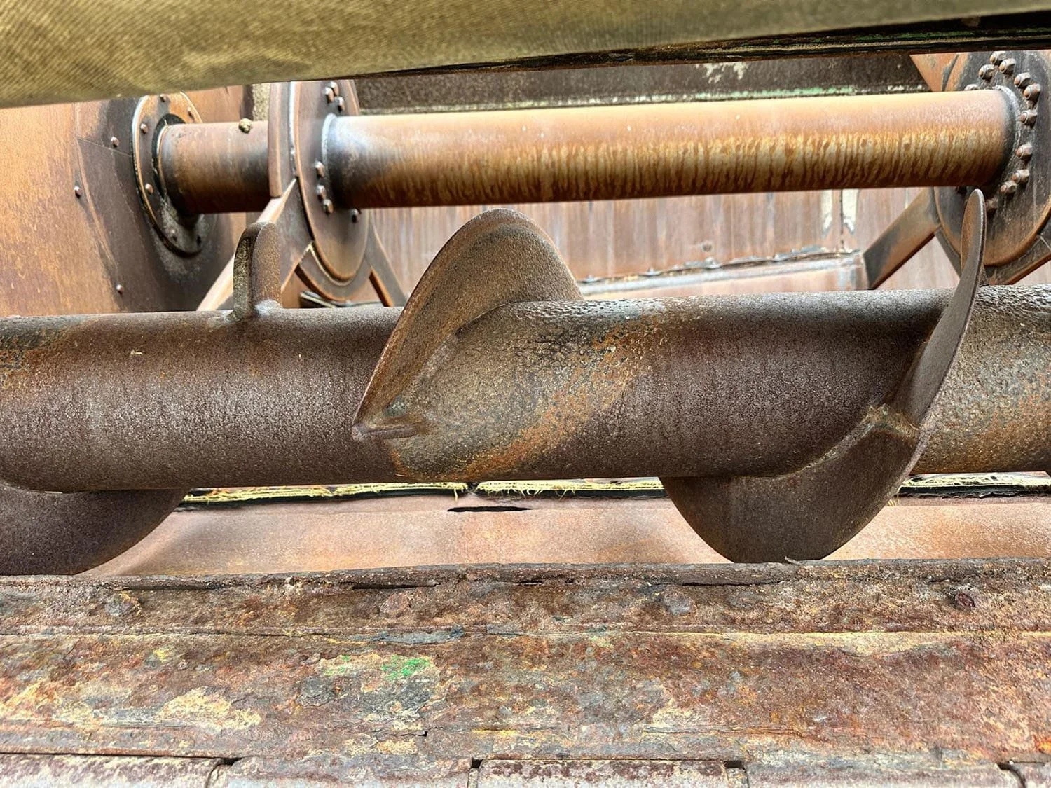 Interior view of the heavy duty horizontal mixing paddles and bale blend processing auger flighting inside a used Keenan MechFiber 340 mixer.