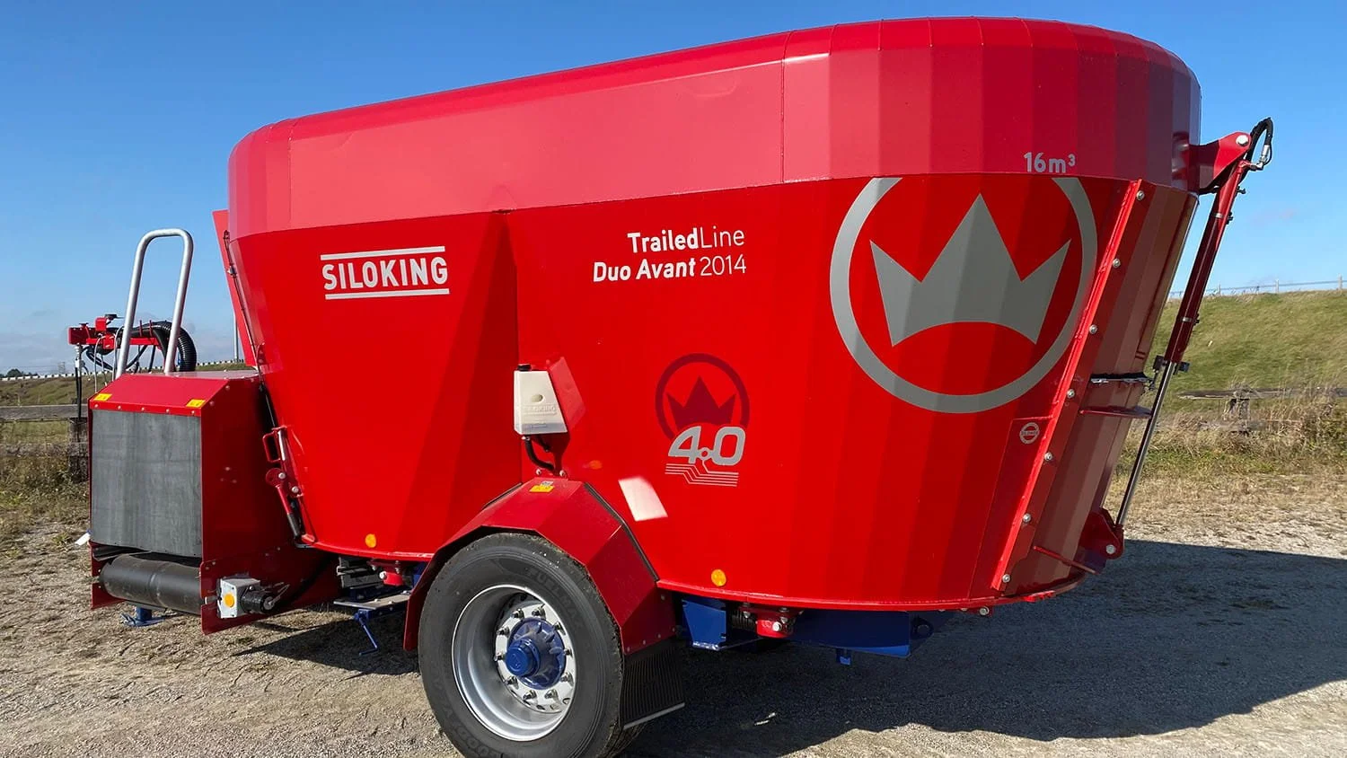 Left-side profile view of a 16 cubic meter red Siloking TrailedLine Duo Avant 2014 twin-auger pull-type TMR mixer parked on a rural driveway.