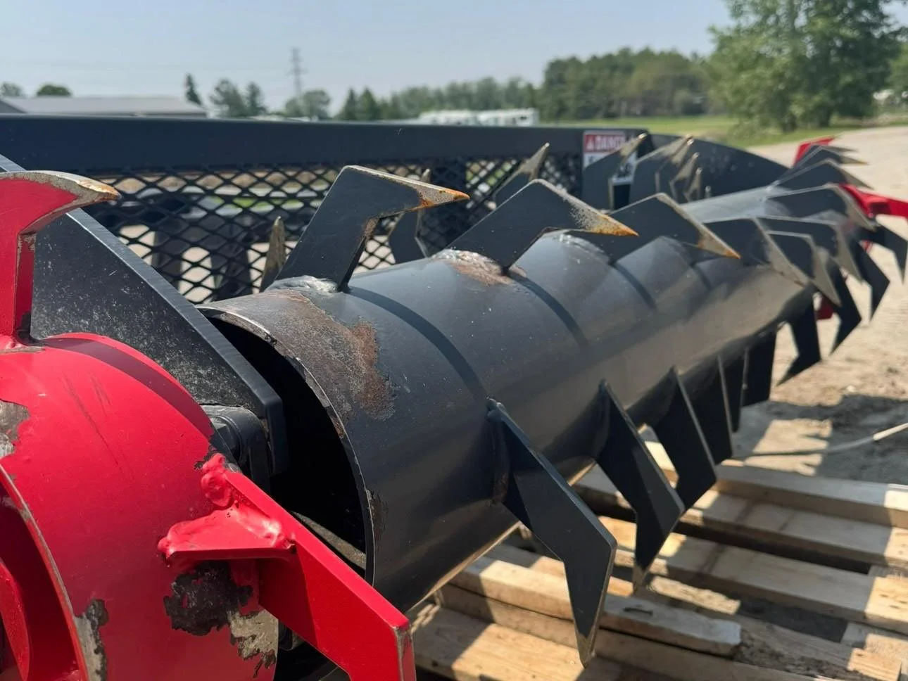 Close-up view of the heavy-duty rotor drum and welded hardened steel face teeth on an 84 inch bunker silage scraper.