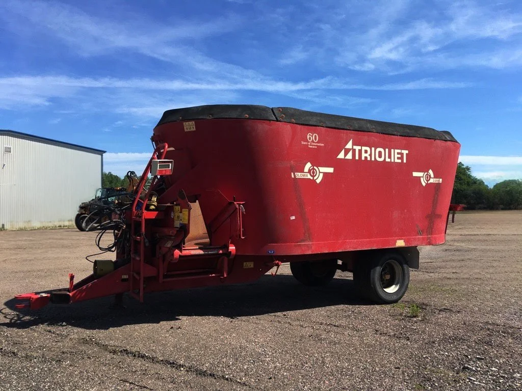 Front three-quarter view of a 2010 Trioliet Solomix 2 2000 vertical mixer wagon showcasing the hitch link and curved front cross-conveyor system.