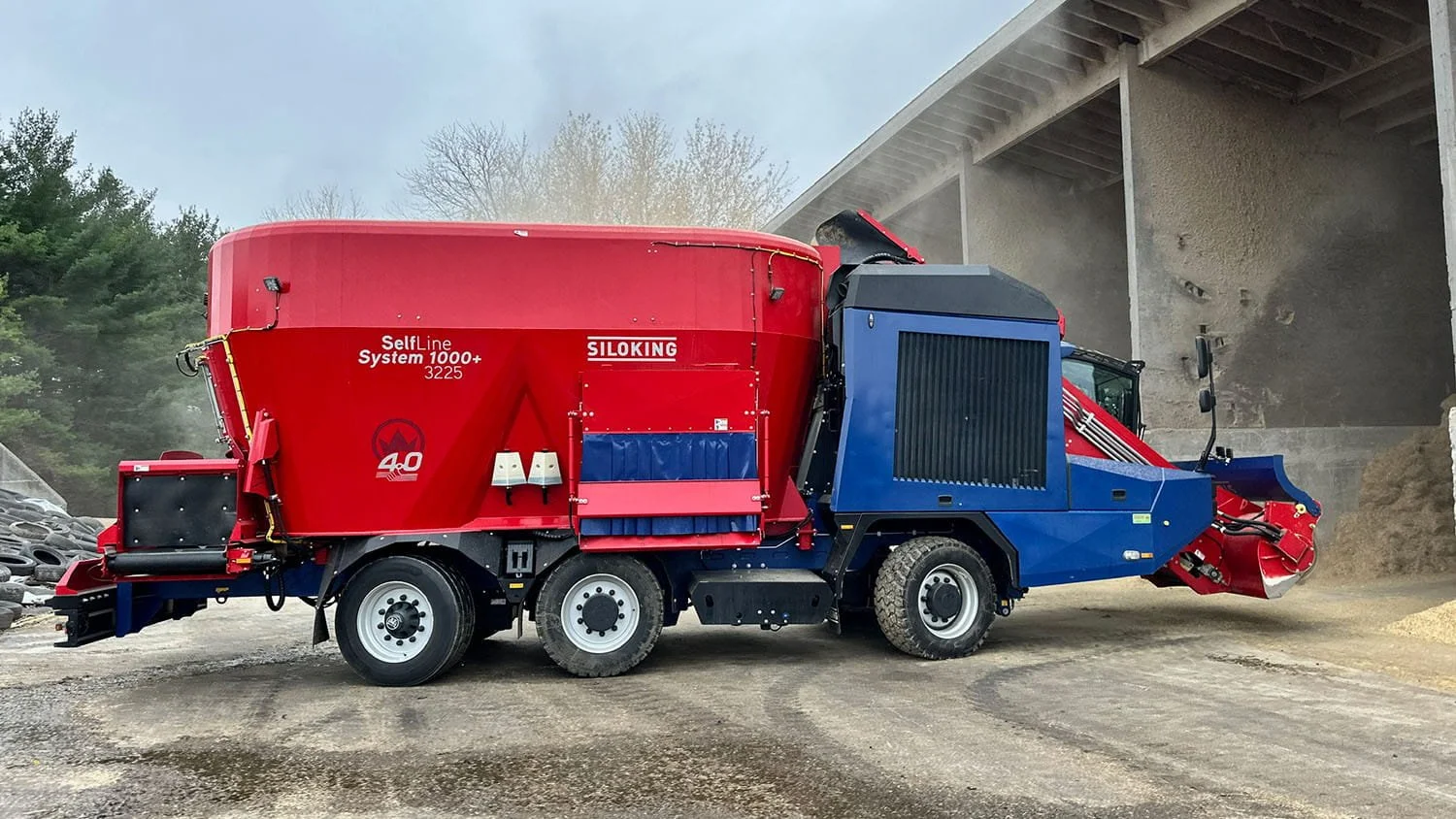 Left-side profile view of a massive triple-axle Siloking SelfLine System 1000 plus vertical feed mixer maneuvering through a concrete bunker storage facility.