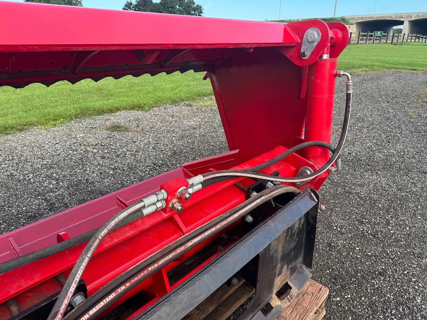 Close-up of the twin hydraulic cylinder setup and hose routing on a 2023 Redrock 180/85 shear bucket.