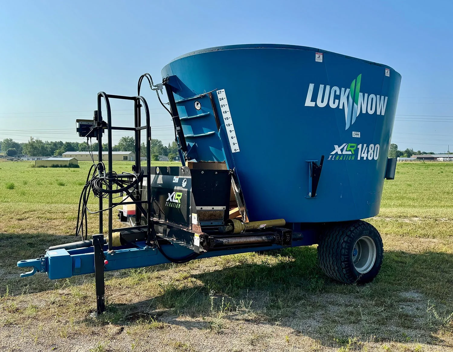 Used Lucknow XLRation 1480 vertical TMR mixer front right profile showing the blue hopper and front cross conveyor in Putnam, ON.