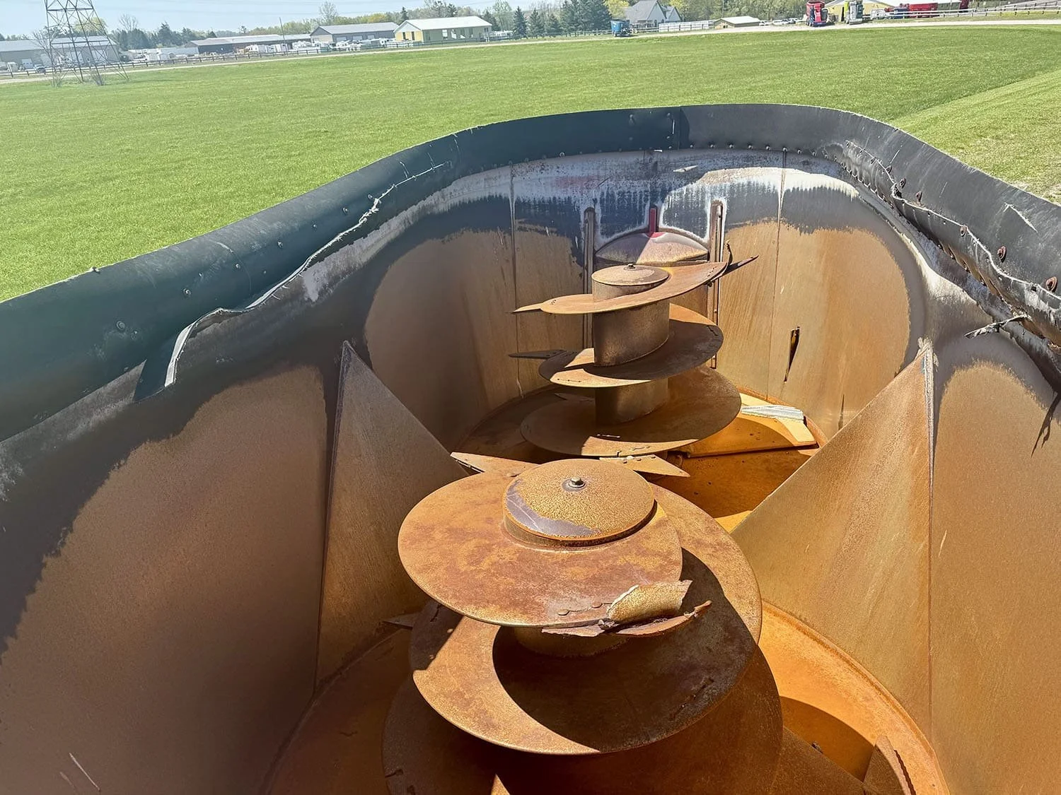 Overhead interior view showing the massive twin vertical mixing augers and tub walls inside a used 25.7 cubic meter Supreme International 1000T feed mixer.