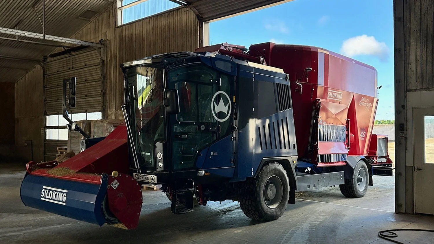 Front view of a Siloking SelfLine System 500 plus inside a modern high-ceiling commercial dairy barn.