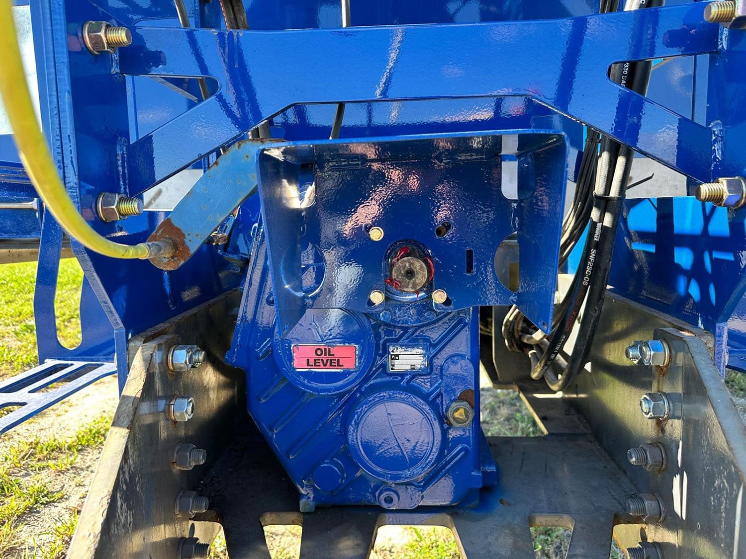 Close-up mechanical view of the heavy-duty 2-speed gearbox and oil level indicator on a pull-type Penta TMR mixer wagon.