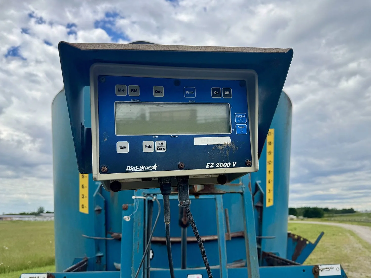 Close-up view of a Digi-Star EZ 2000 V digital weigh scale monitor mounted on a blue Lucknow 2290 vertical mixer wagon.
