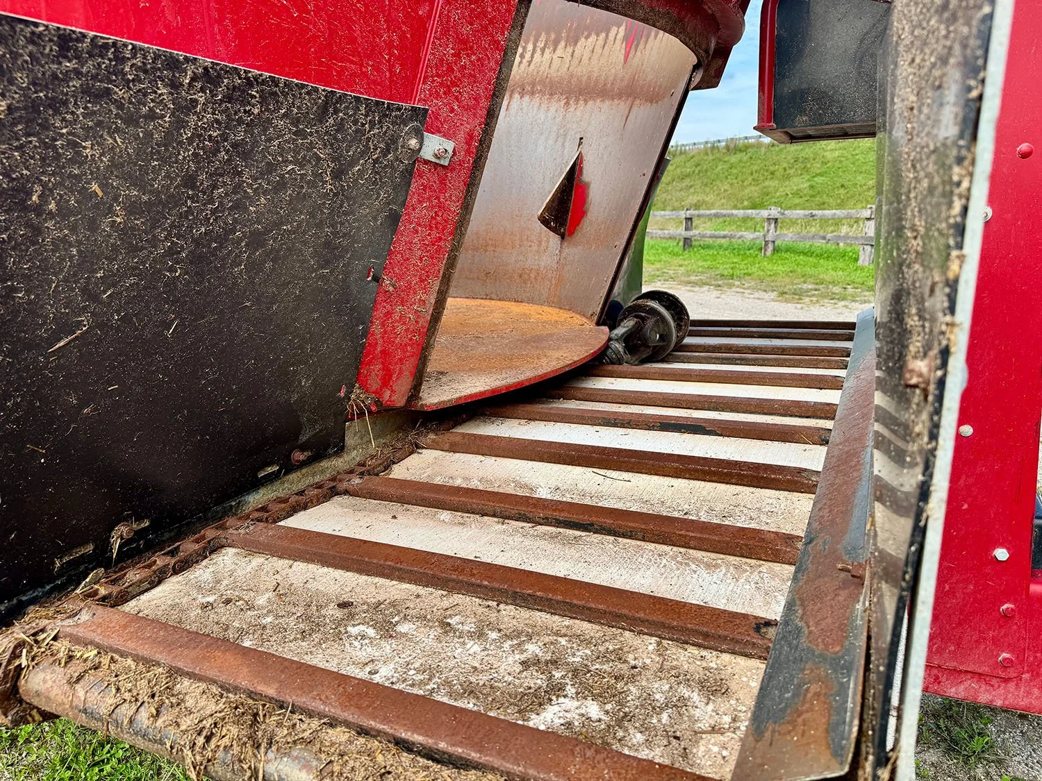 Close-up view of the front flat cross conveyor discharge bed and discharge door on a used 2021 Jaylor 5850 TMR mixer wagon.