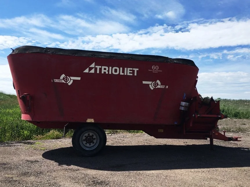 Full right side profile view of a red 2010 Trioliet Solomix 2 2000 vertical TMR mixer wagon featuring a 12-inch rubber tub extension.