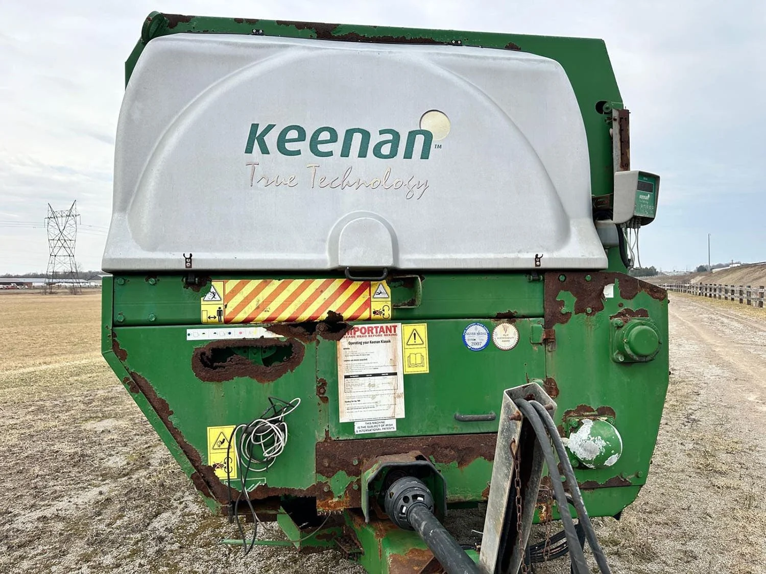 Front close-up view of the main PTO drive shaft connection, front shield panels, and weighing system mount on a Keenan horizontal mixer wagon.
