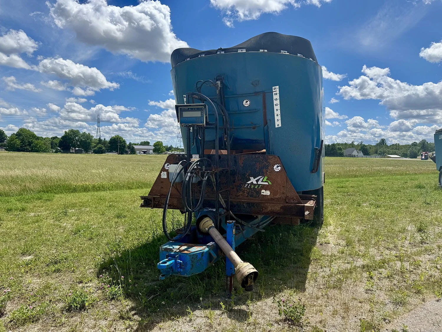 Front view of a Lucknow XLR2950 vertical mixer showing the PTO drive shaft, hitch connection, and digital weigh scale monitor.