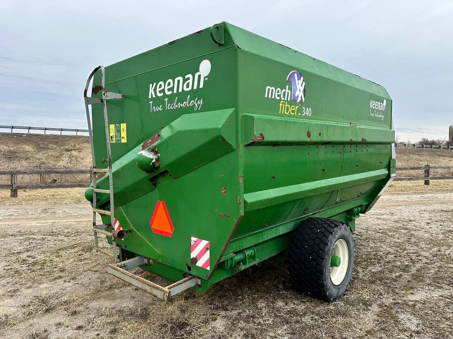 Rear three-quarter view of a green used Keenan MechFiber 340 horizontal feed mixer wagon showing the rear inspection ladder.