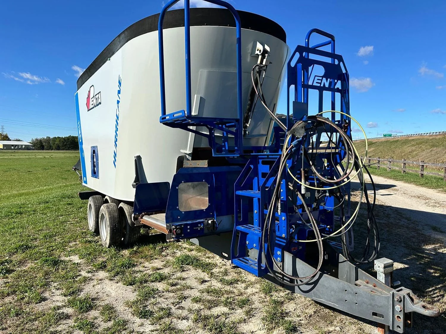 Front three-quarter view of a used 2017 Penta 1130HD vertical feed mixer showing the operator platform and front cross conveyor assembly.