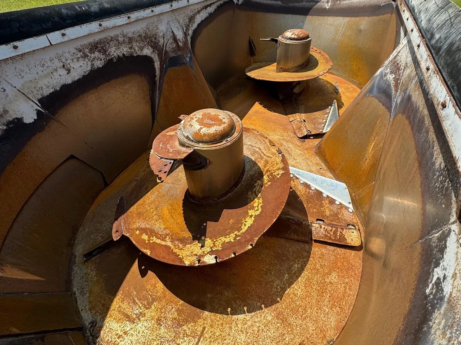 Overhead interior view showing the dual vertical Tornado mixing augers and adjustable hay restrictor plates inside a used 19.8 cubic meter Penta feed mixer tub.