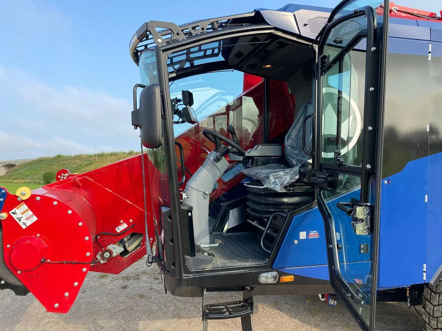 Close-up interior view of the premium driver cab on a new Siloking SelfLine 500+ self-propelled feed mixer with the door open, showcasing the steering console and protective seat covers.