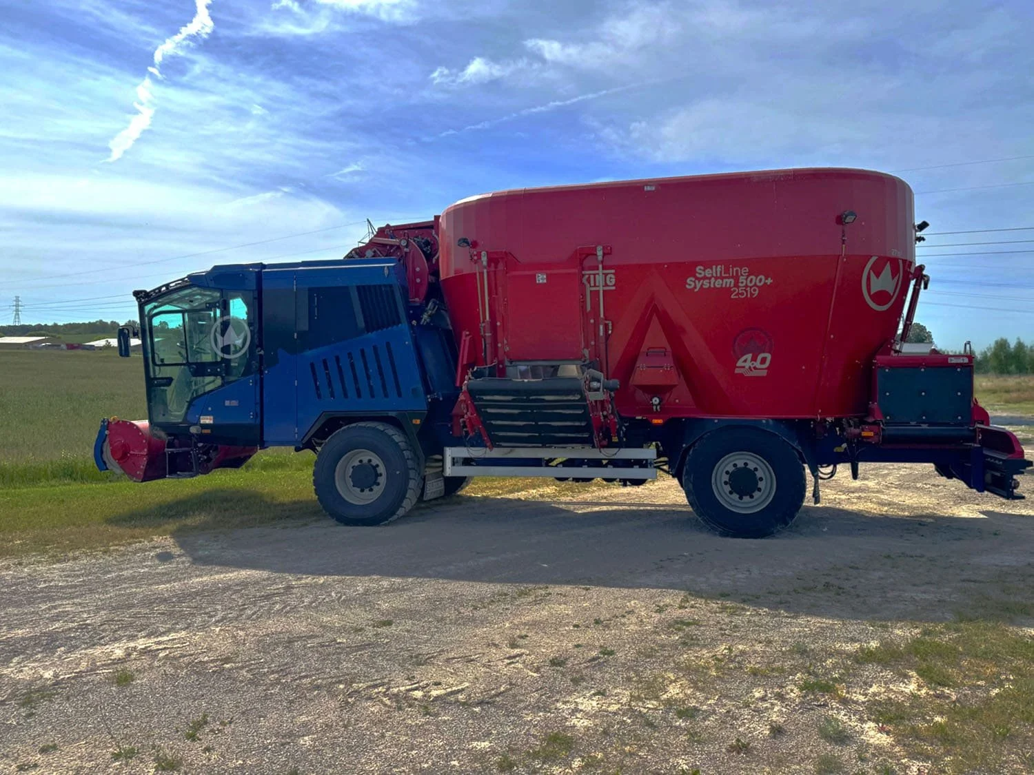 Left side profile view of a red and blue 2022 Siloking SelfLine 4.0 System 500+ 2519-27 4x4 self-propelled vertical TMR mixer wagon for sale at Siloking Canada.
