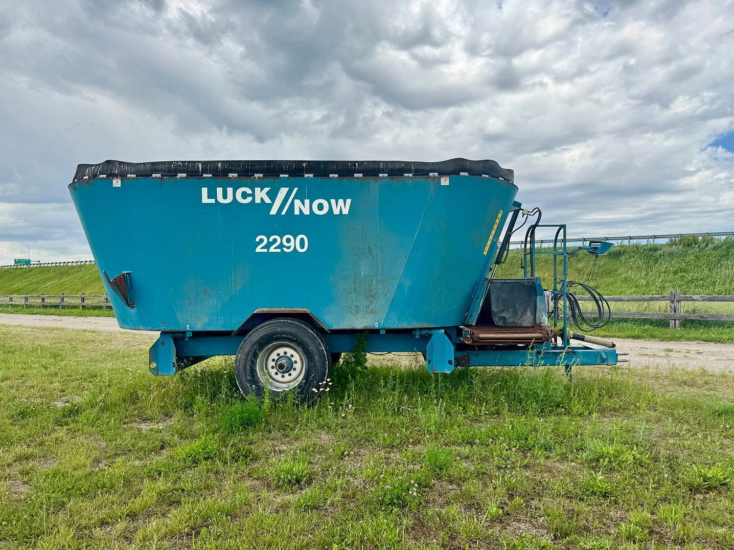Full left side profile view of a blue Lucknow 2290 vertical mixer wagon showing the large white model decals and single wheel assembly.