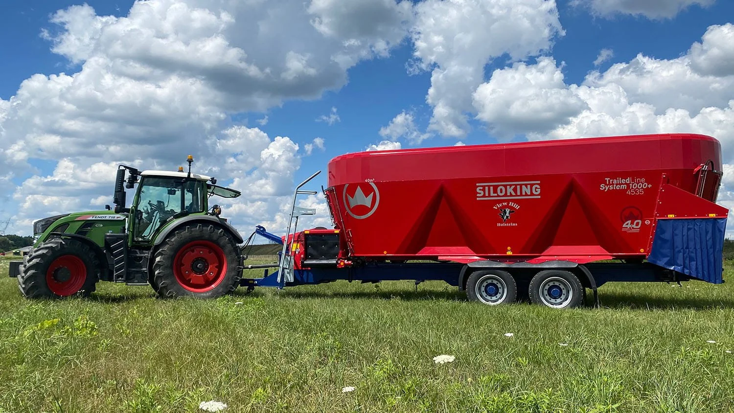 A high-capacity Siloking TrailedLine System 1000 plus vertical TMR mixer wagon hitched to a Fendt farm tractor in an open pasture field.