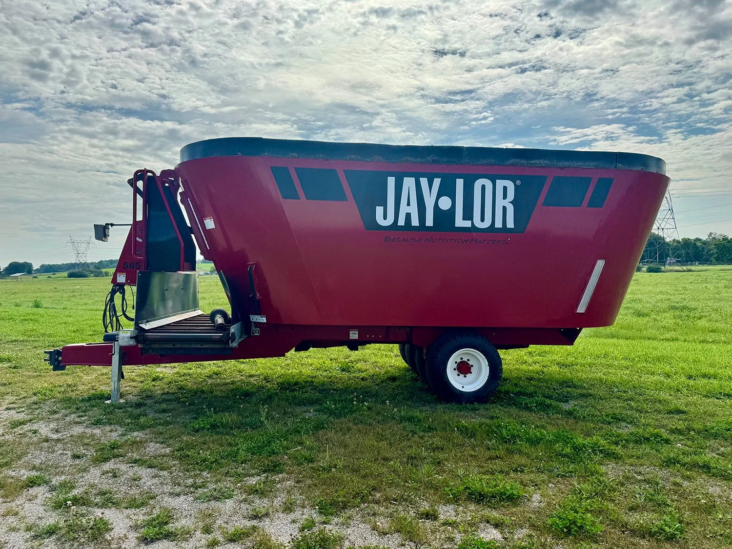 Front right profile of a used red 2021 Jaylor 5850 twin auger vertical TMR mixer wagon with top extensions on display at Siloking Canada.
