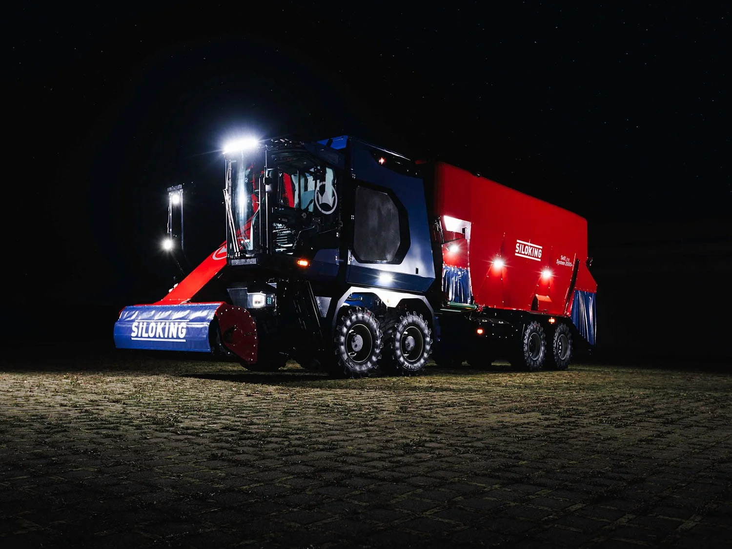 A high-capacity Siloking SelfLine System 2000 plus industrial mixer wagon operating at night, illuminated by heavy-duty LED work lights and under-chassis safety lighting.