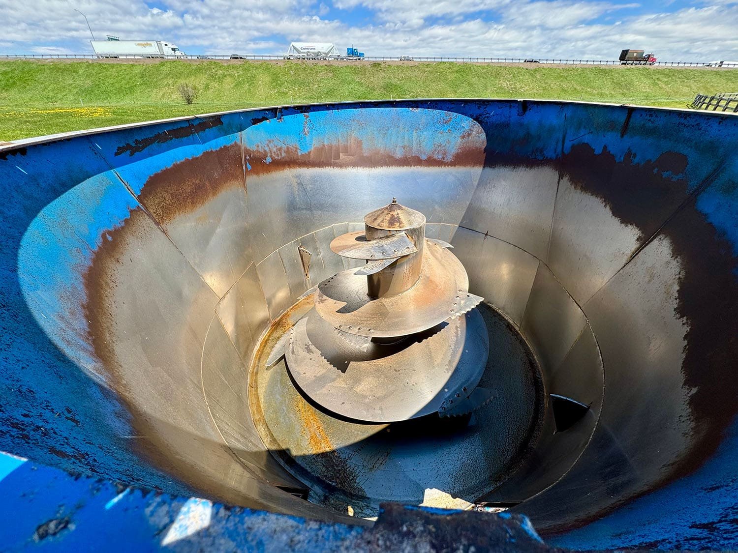 Overhead interior view showing the single vertical mixing auger and a premium stainless steel inner tub liner wrapper inside a used Patz V615 feed mixer.
