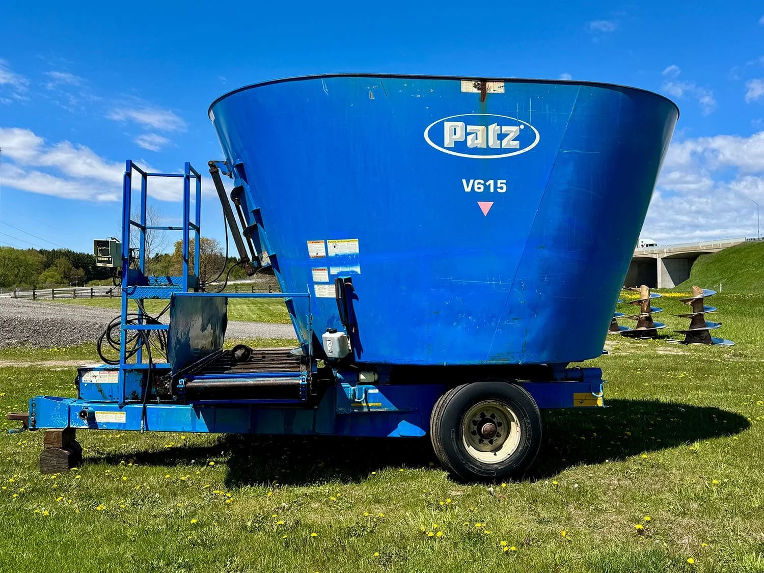 Left side profile view of a blue used Patz V615 trailed single auger vertical TMR feed mixer wagon for sale at Siloking Canada.