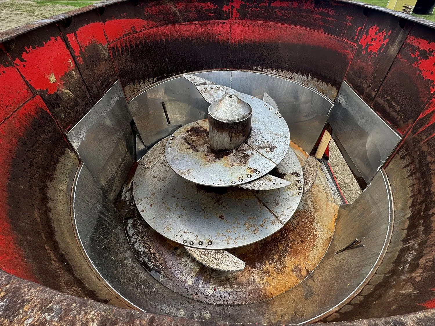 Overhead interior view showing the single vertical mixing auger and installed stainless steel inner tub liner wrapper inside a used 17.6 cubic meter NDE feed mixer.
