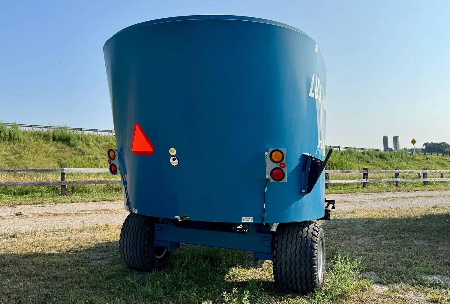Rear view of a used Lucknow 1480 vertical feed mixer showing transport lighting and slow-moving vehicle sign.