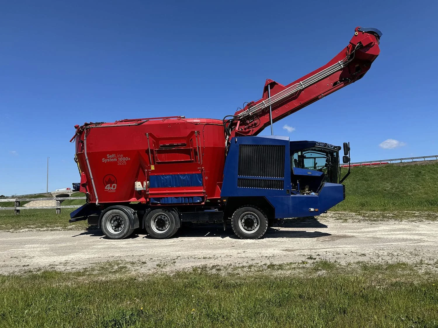 Right side view of a used Siloking SelfLine 4.0 System 1000+ 3225 showing the high-reach silage milling loader arm fully raised against a clear blue sky.