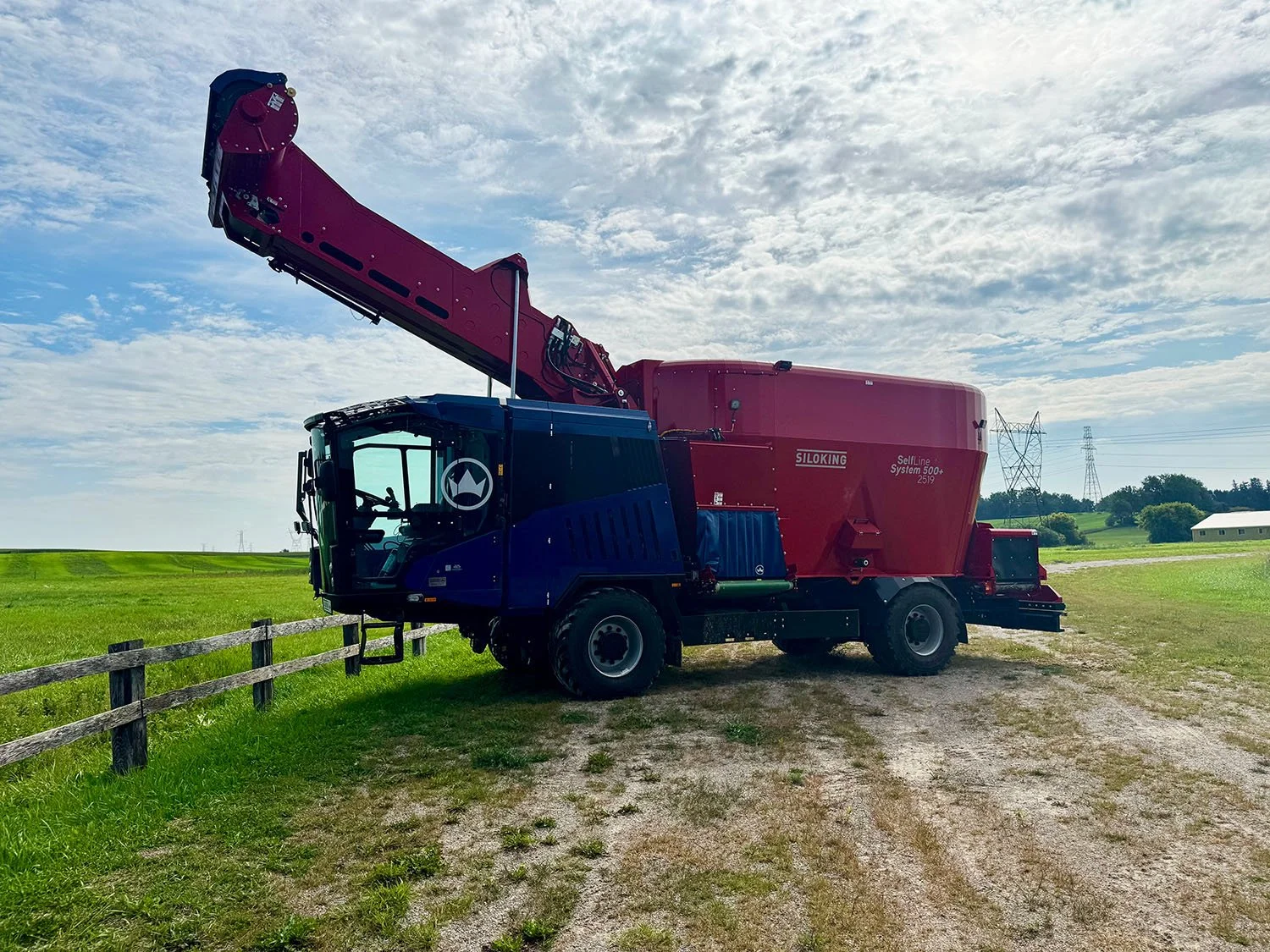 New red and blue SILOKING SelfLine 4.0 System 500+ 2519-27 4x4 self-propelled TMR mixer wagon with high-reach loading arm raised