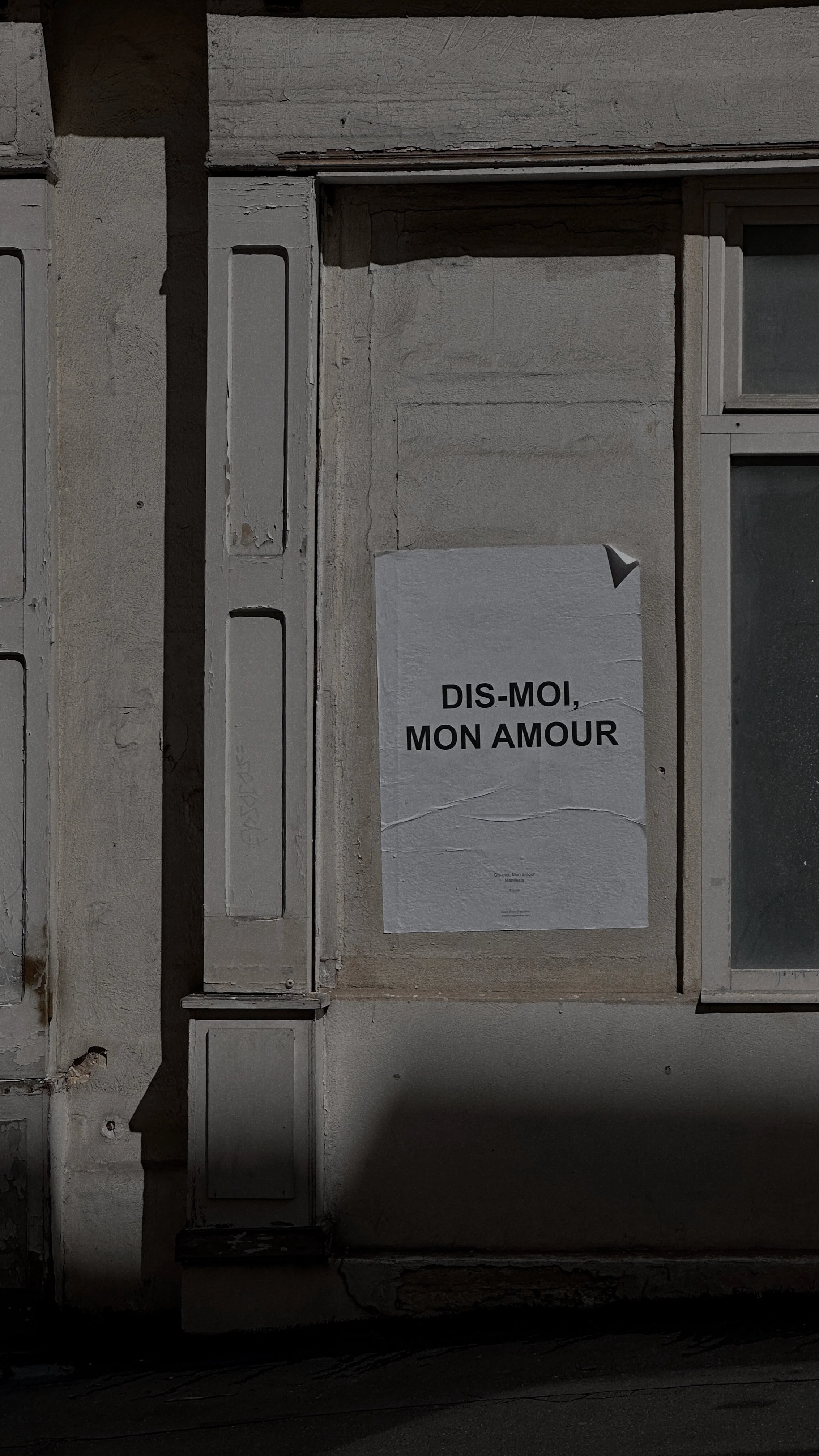 Plakat an einer alten Hauswand mit dem Text 'DIS-MOI, MON AMOUR'