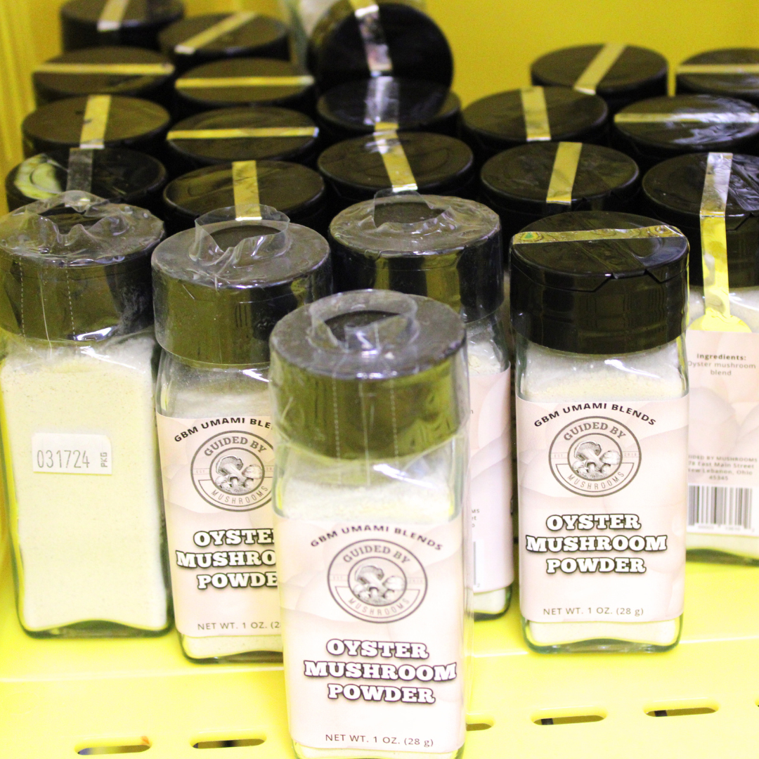 Multiple jars of oyster mushroom powder on a yellow store shelf, Guided by Mushrooms