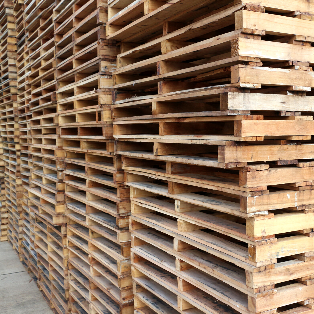 Stacks of wooden pallets arranged outdoors.