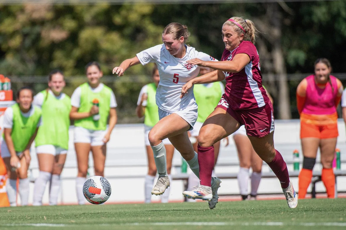 Collegiate soccer athletes competing during a match