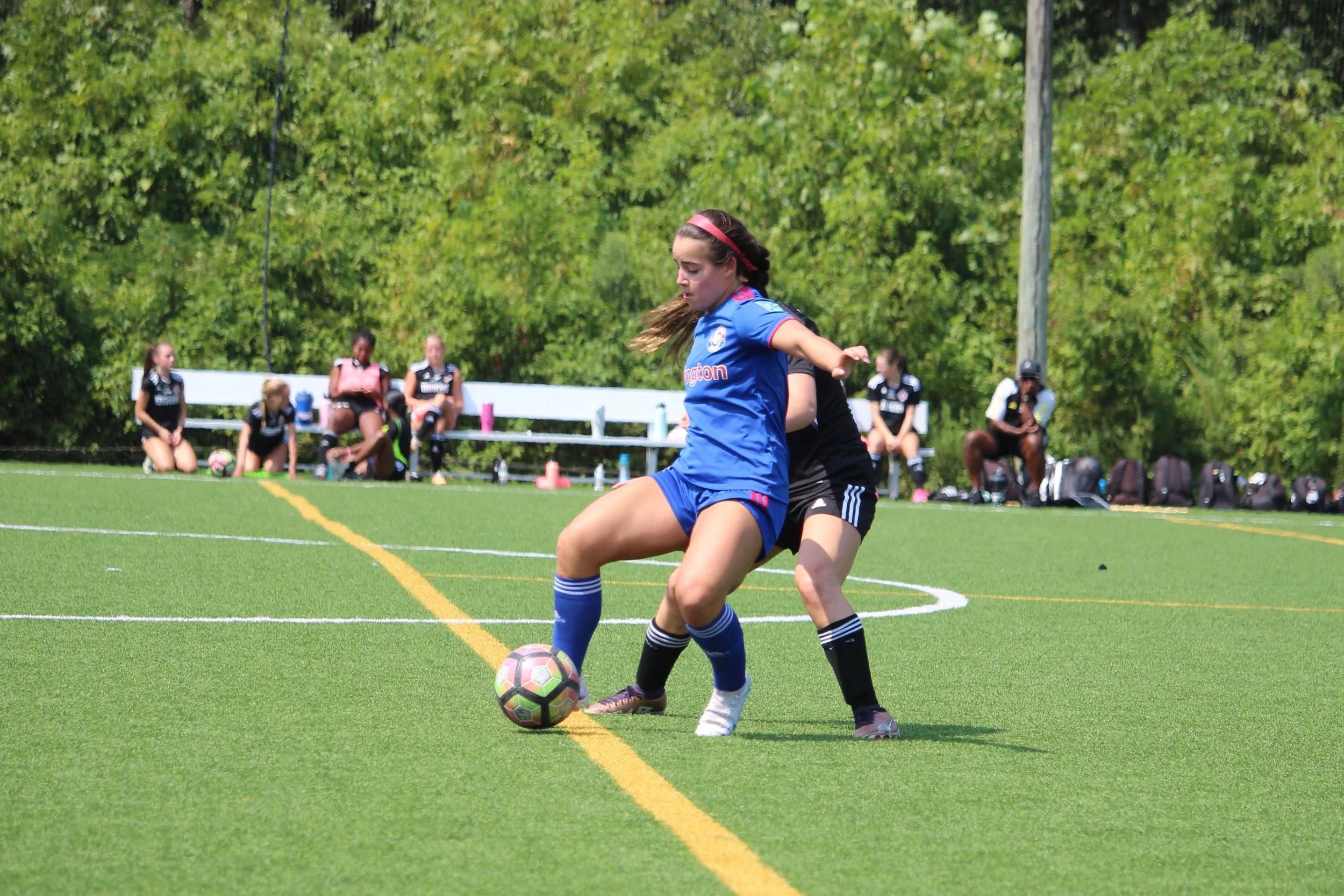Female soccer players competing for possession during a match.