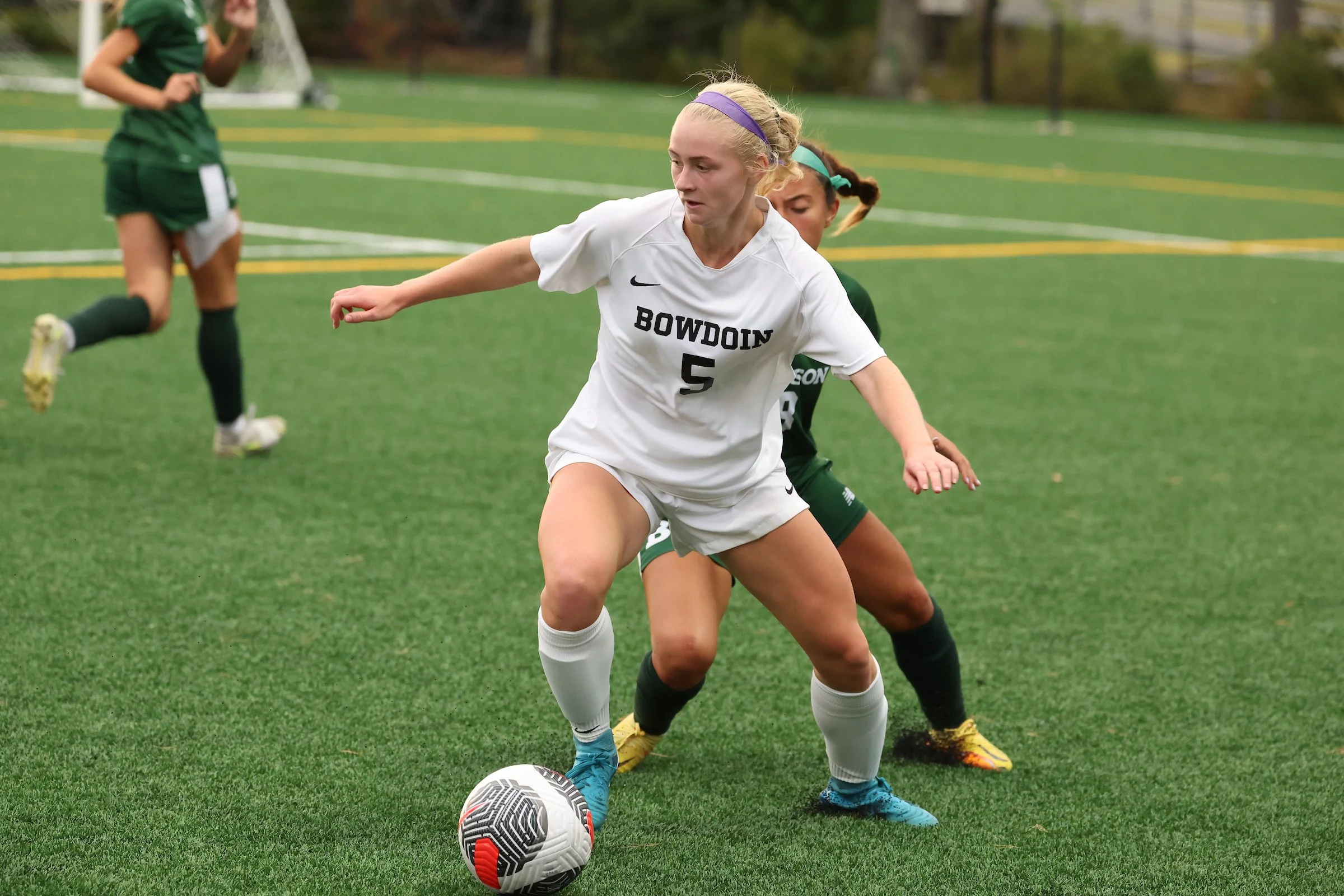 Collegiate soccer athlete competing during a match.