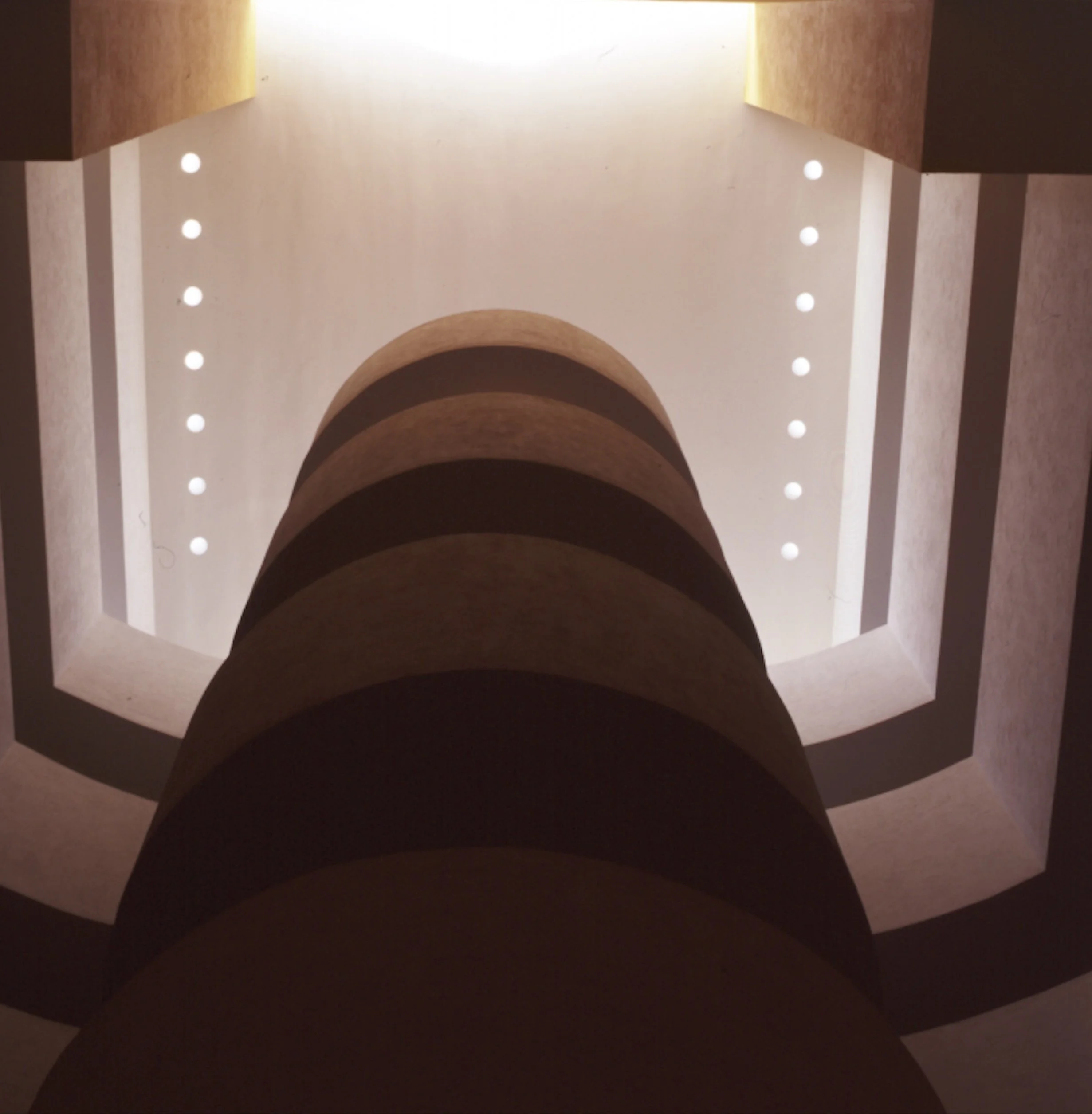 Vista del interior de un edificio, mostrando un techo con iluminación empotrada y arcos de madera, estructura moderna y decorativa.