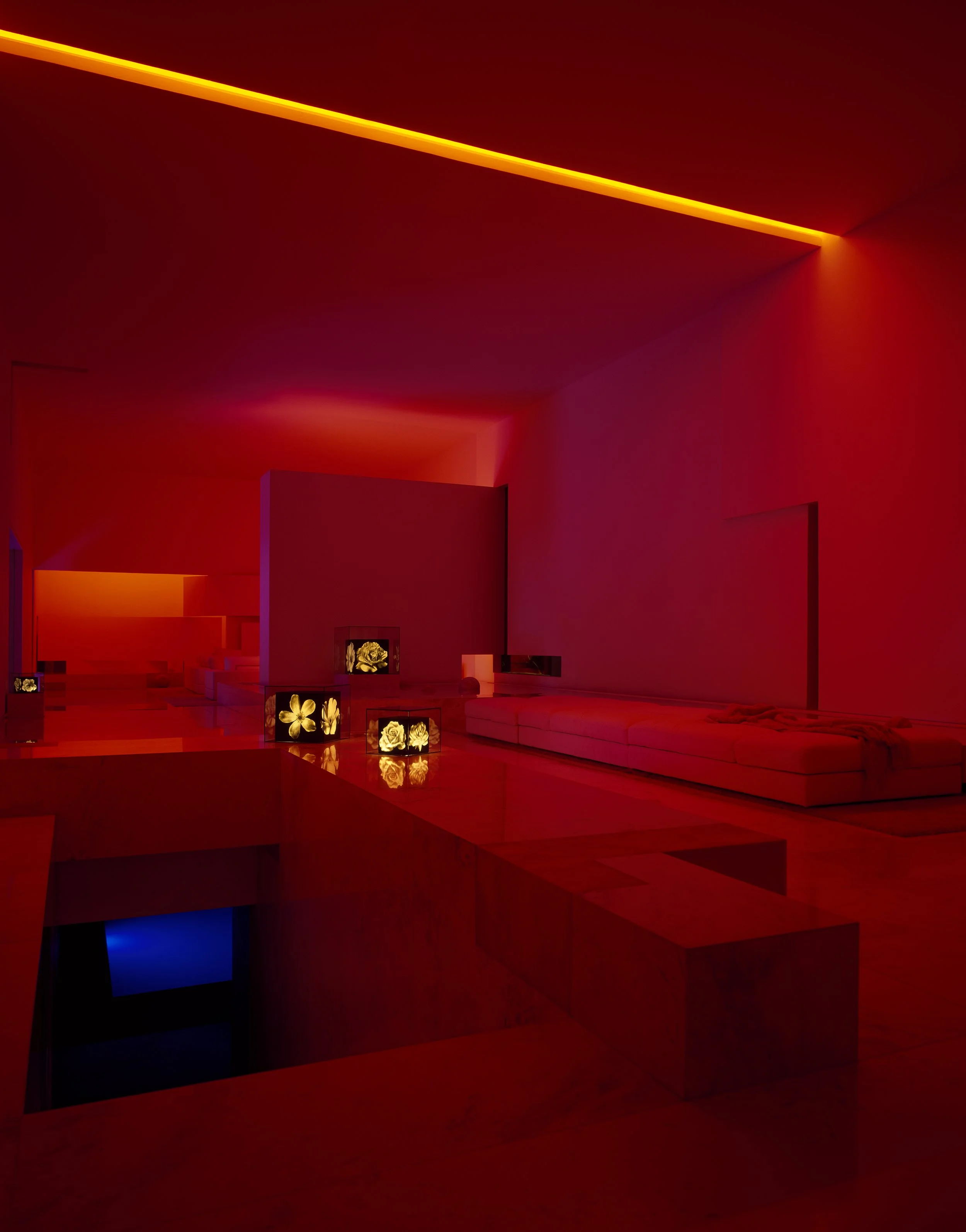Interior con paredes y techo en tonos rojos y naranja, iluminación difusa y decoraciones florales en cuadros. Architecture & Design by Miguel Ángel Aragonés | Taller Aragonés. Photography by Nicola Lorusso