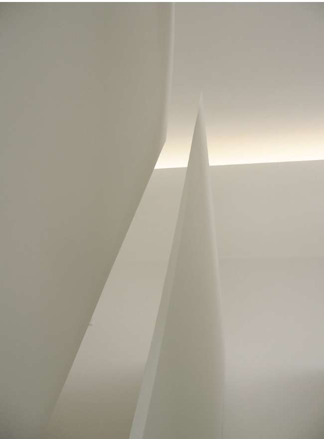 Vista abstracta de superficies blancas con líneas y formas geométricas.