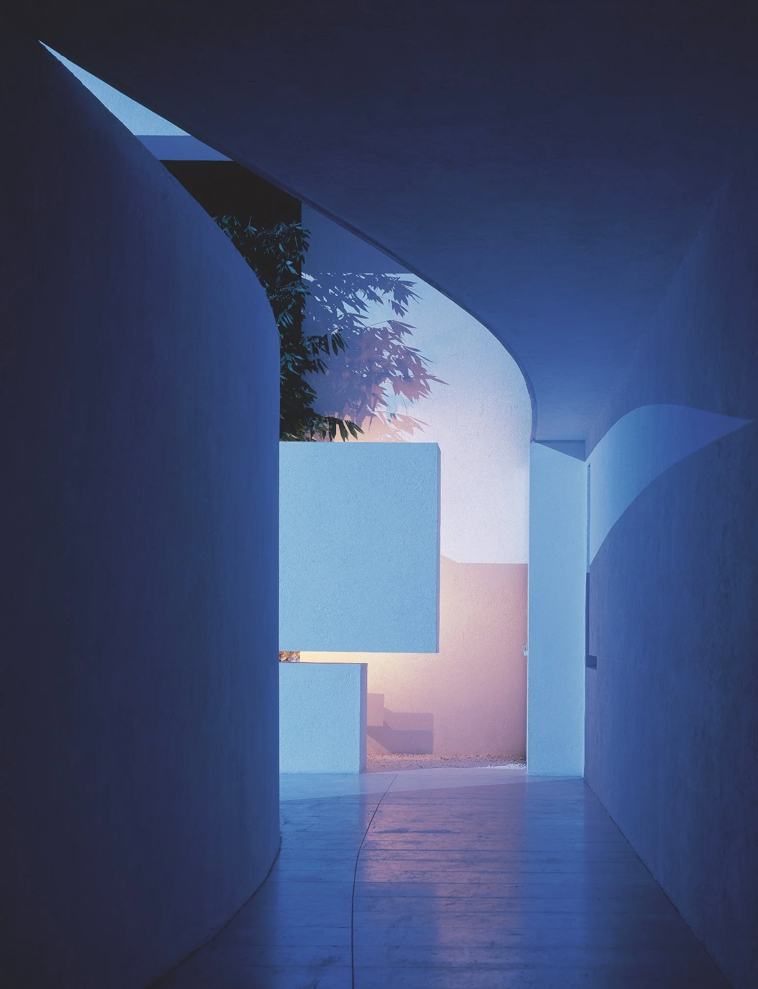 Interior de un edificio con paredes blancas y un arco, con luz natural de la tarde, mostrando una vista del exterior con plantas y un cielo con tonos rosados y azules. Eucaliptos 65, Architecture & Design by Rafael Aragonés Caballero & Miguel Ángel A