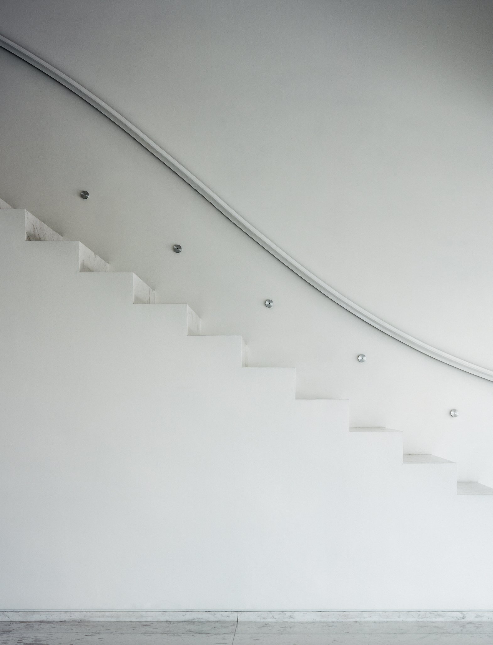 Escalinata moderna blanca con barandilla curva y luces empotradas en el techo. Casa Olivia, Architecture & Design by Miguel Ángel Aragonés | Taller Aragonés. Photo by Nicola Lorusso