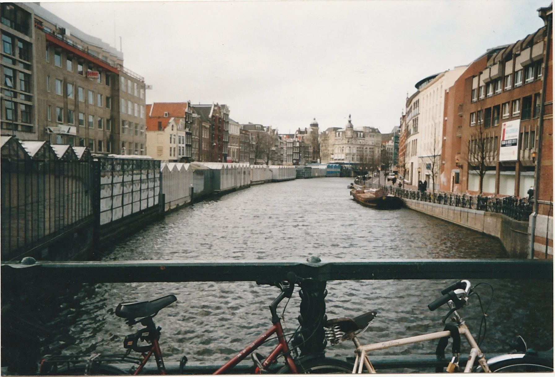Canal lined with warehouses and historic buildings reflected in moving water.