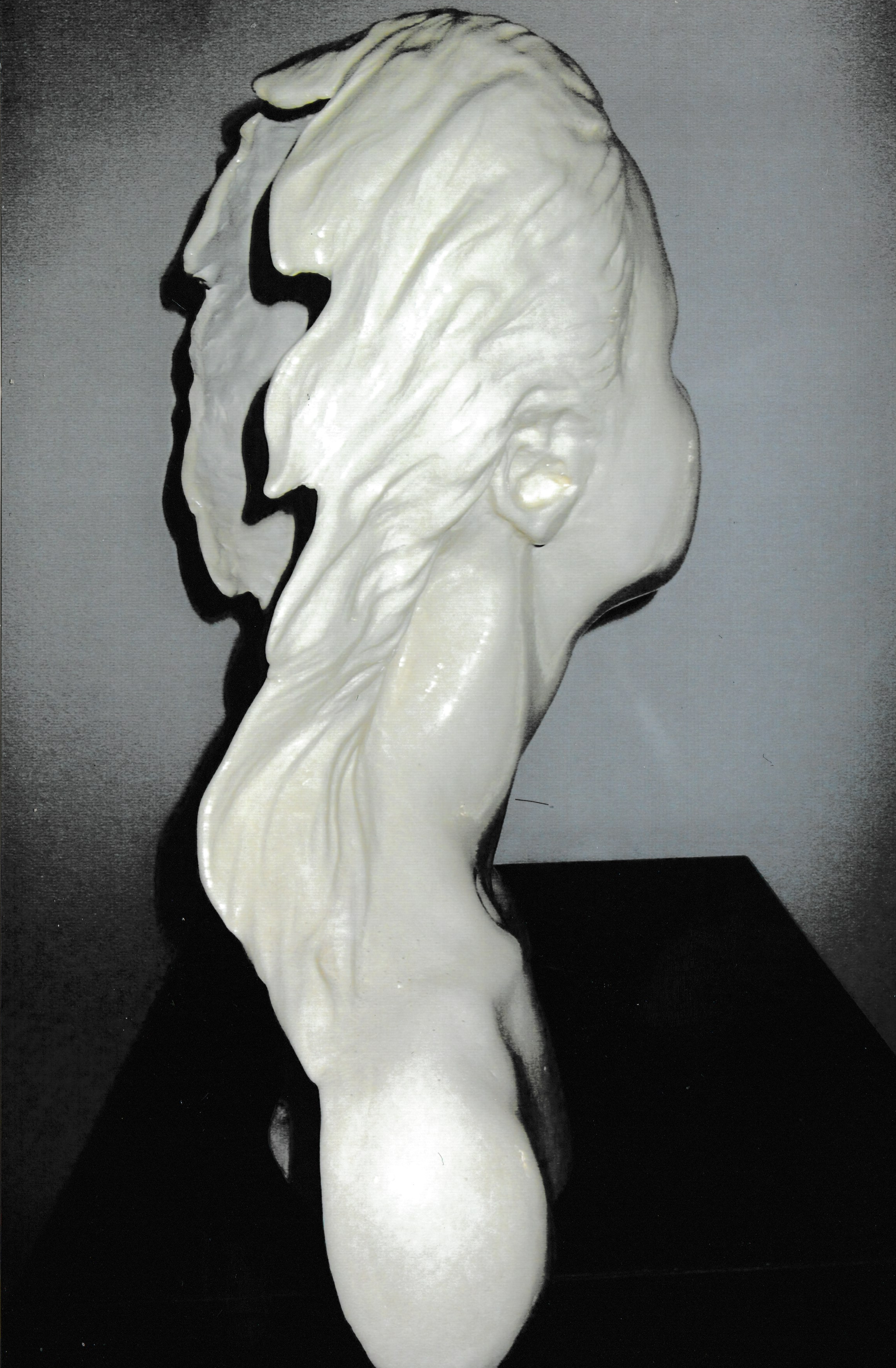 Rear view of a ceramic life cast bust, highlighting long hair gathered into a low ponytail flowing down the neck.