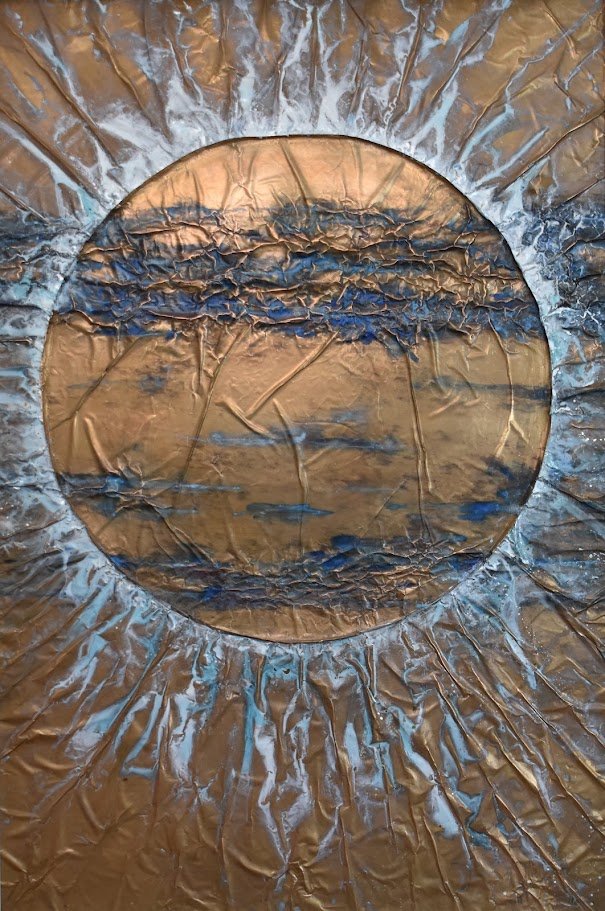 A golden orb radiates through currents of blue and silver. Shown close up without a frame.